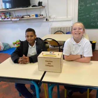 élève à coté d'une urne